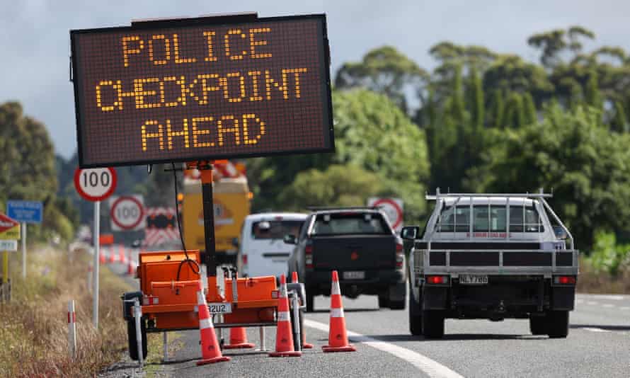 Las señales cuentan a los viajeros mientras la policía verifica que un viajero en dirección norte haya pasado sus vacunas o pruebas de virus negativas en el puesto de control de Northland en Auckland.