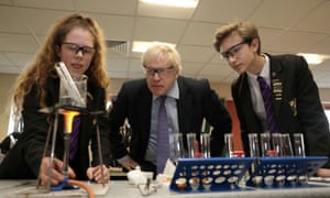 Boris Johnson watching students Ruby Culter and Matthew Upright performing a science experiment during his visit to Chulmleigh College in Devon.