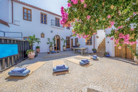 A whitewashed house with yoga mats laid out in its courtyard