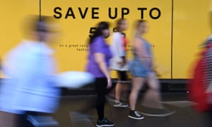 Pedestrians walks past an advertisement outside a department store in Sydney, 5 October 2016.