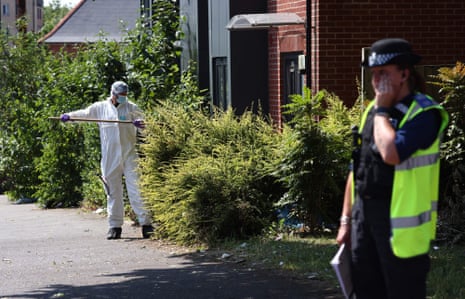 A police forensics officer conducts a search on Ilkeston Road in Nottingham.