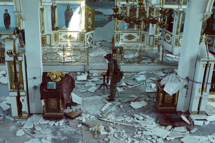 Dzhango lighting a candle in the damaged church.