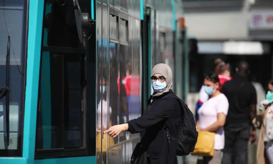 A passenger wearing a protective face mask boards a tram in Frankfurt