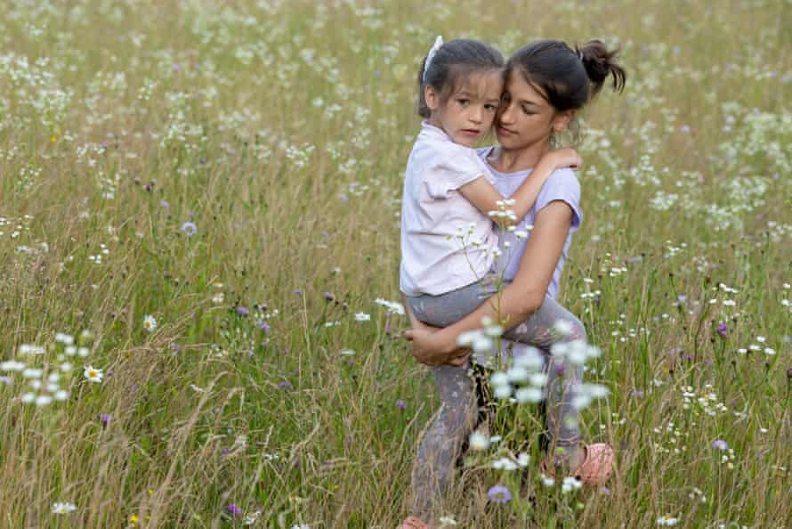 Tina, 13, carries her young cousin