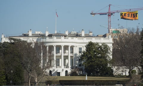 Greenpeace protesters unfold a bannerfrom atop a construction crane behind the White House Wednesday.