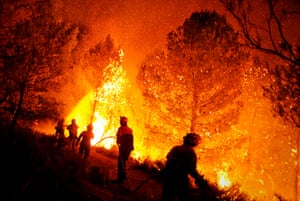 Fireﬁghters try to extinguish a blaze near Alicante in Spain, one of a series of forest ﬁres across the south of the country.