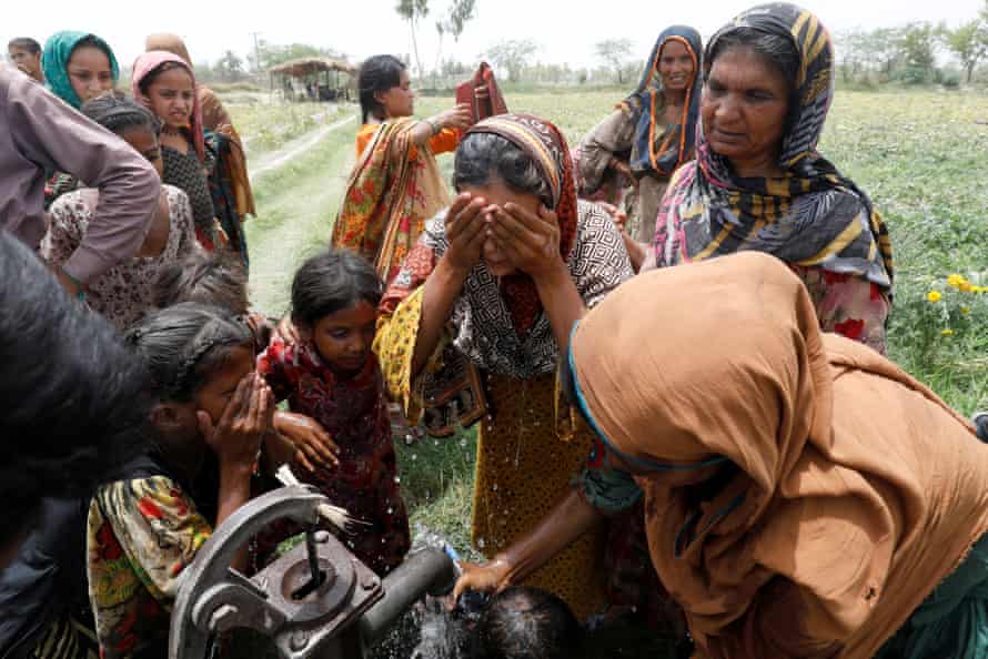 Women and children wash themselves at a hand pump after work at a muskmelon farm on the outskirts of Jacobabad, Pakistan during a heatwave on 17 May.