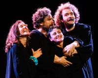 Actors from Underground Monk Show embrace and laugh together in dark robes on stage
