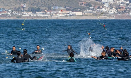 Surfers throw flowers during a tribute to three missing surfers in Ensenada, Mexico.