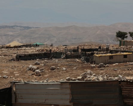 A bedouin community in the foreground with an Israeli settler outpost visible in the background.