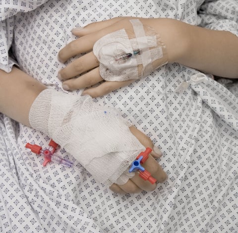 close up photograph of patient’s hands in hospital bed