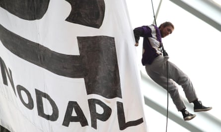 A protester hangs by a harness from the rafters during the second quarter of the game.