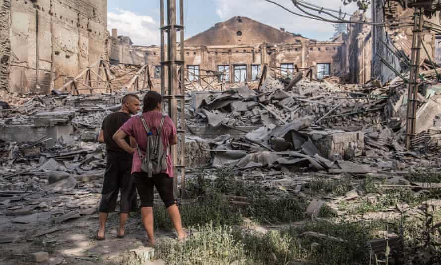 Locals look at destroyed buildings in Lysychansk after heavy fighting in the Luhansk area, Ukraine.