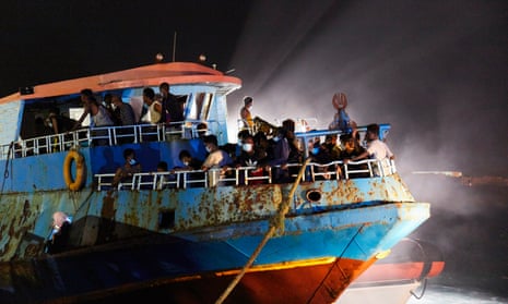 A fishing ship escorted by the Italian coastguard brings migrants to Lampedusa, Italy. 
