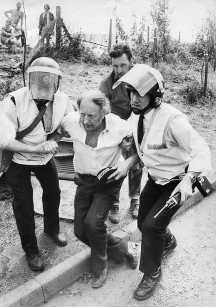 Arthur Scargill being helped by two ambulance officers