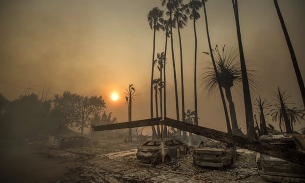 Smoke rises behind a destroyed apartment complex and burned out cars after the Thomas fire ripped through Ventura, California