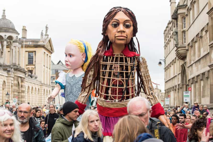 Little Amal meets Alice in Wonderland in Oxford.