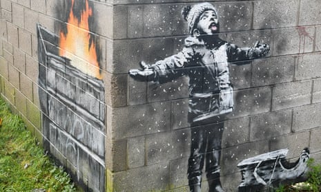 Banksy mural of child with arms and tongue out catching snow, with painting around the corner showing snow is actually ash from furnace