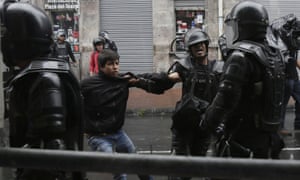 A demonstrator is detained by the police in Quito.