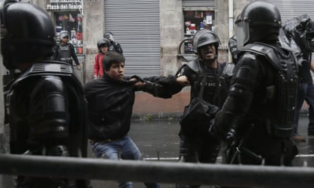 A demonstrator is detained by the police in Quito.