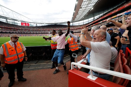 A Chelsea supporter is escorted out of the ground by Arsenal stewards.