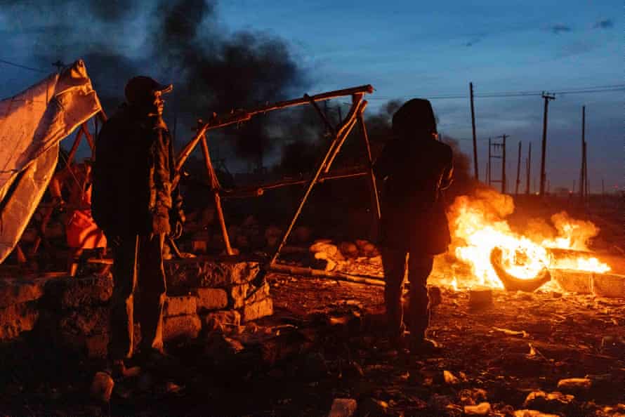 People burn tyres to keep warm in a makeshift displacement camp