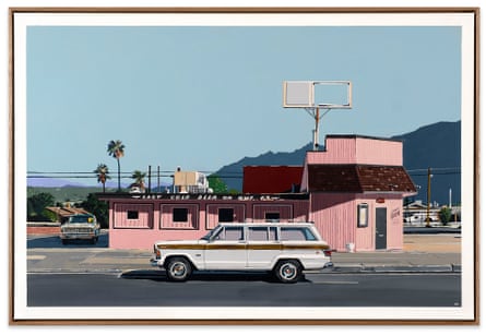 An old car in front of a pink building