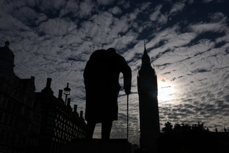 Elizabeth Tower, more commonly known as Big Ben, and the statue of Winston Churchill in Parliament Square at night.