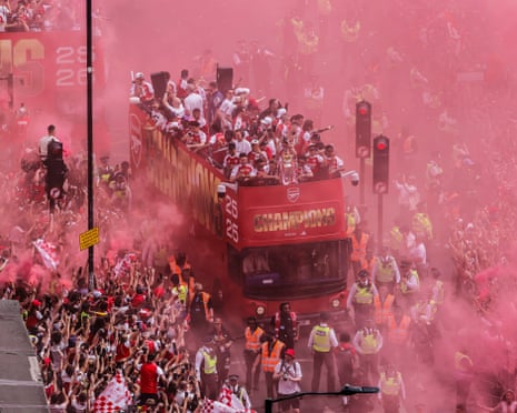 The Arsenal players show off the Premier League trophy as their bus makes its way on to Holloway Road at the start of their victory parade in north London