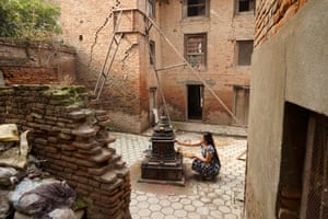 A woman performs 'puja' or worship outside her home in Kathmandu