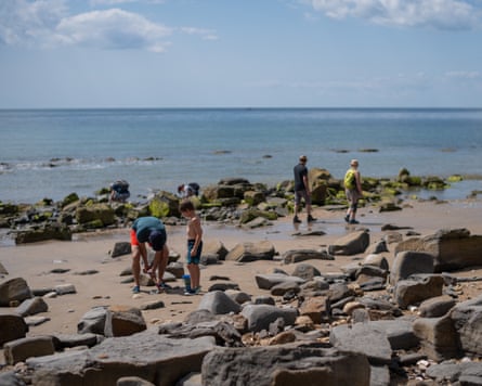 People walking on a rocky beach
