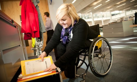 Young disabled woman in a wheelchair working filing documents.