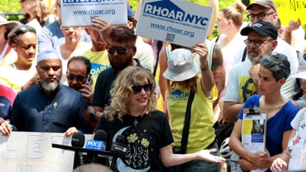 people hold signs that say ‘RHOAR NYC’