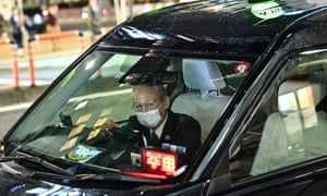 A taxi driver in Tokyo waits for customers at night.