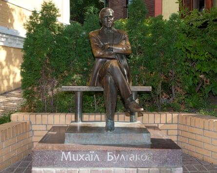 Statue of a Bulgakov sitting on a bench with his arms folded
