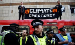 Police officers attend the scene of the Extinction Rebellion protest at Canary Wharf DLR station on 17 April