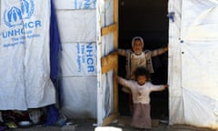 Displaced children stand outside a makeshift shelter at a camp for internally displaced people in the northern province of Amran, Yemen