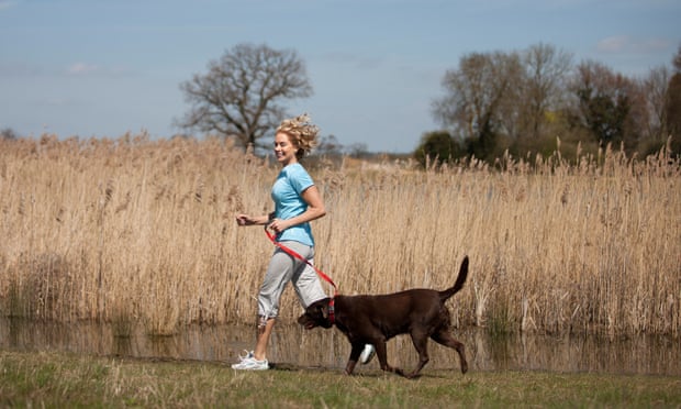 A woman jogging with her dog