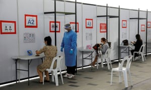 People take their antigen rapid test under supervision, at a Quick Test Centre in Singapore