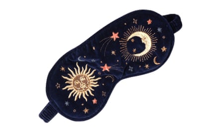 A navy blue Elizabeth Scarlett eye mask with gold embroidered sun, moon and stars