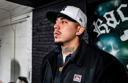 Man wearing a white baseball cap and with a tattoo on his nect stares