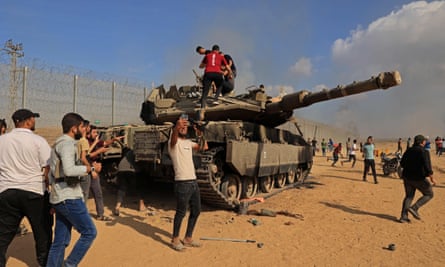 People climbing on top of a tank and taking selfies