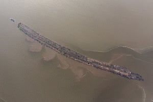 A tug boat pulls a line of log rafts in Lagos