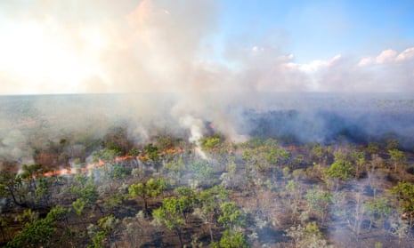 A fire front is seen from an R44 helicopter that has just dropped incendiary devices during an aerial burn over the Oriners and Sefton Savannah Burning Project site in Cape York, Queensland on 27 June 2016.