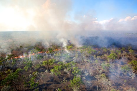 A fire front is seen from an R44 helicopter that has just dropped incendiary devices during an aerial burn over the Oriners and Sefton Savannah Burning Project site in Cape York