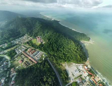 An aerial image of a coastal development surrounded by dense forest.