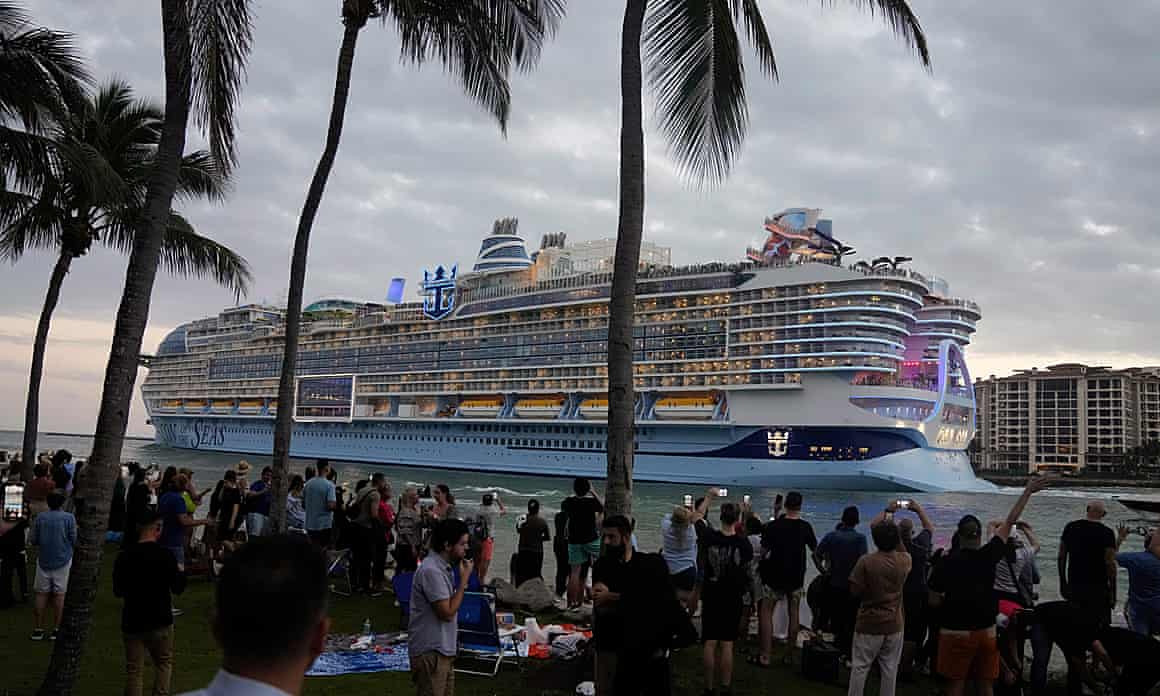 Huge cruise shift sailing out of Miami with palm trees in foreground