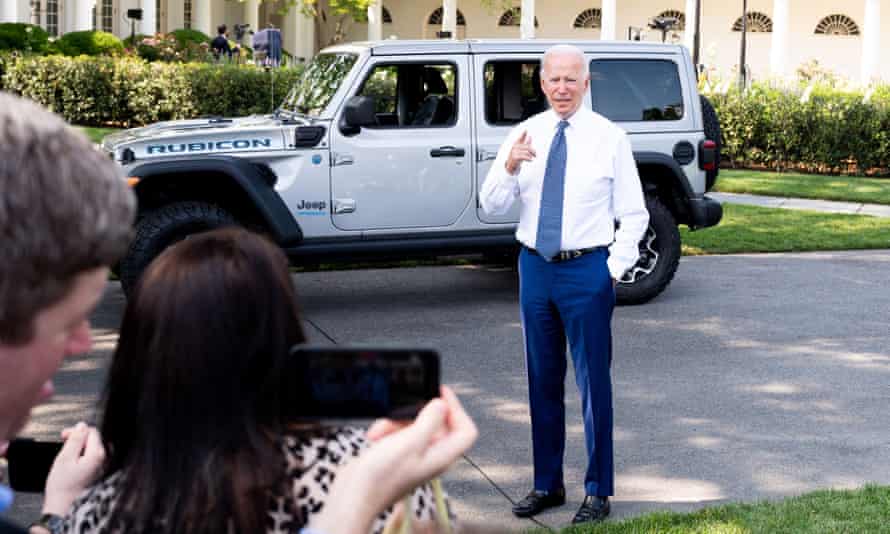 President Joe Biden talks to reporters in front of a Jeep hybrid