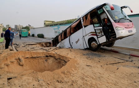 A bus lies in a crater following Israeli strikes outside the European hospital complex near Khan Younis in Gaza.