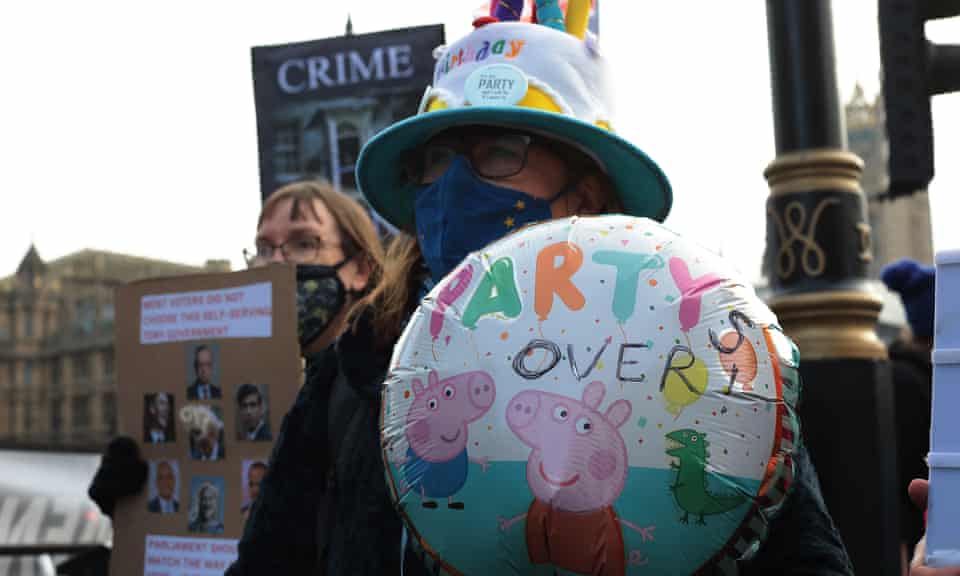 A protester wears a birthday cake hat outside the Palace of Westminster.